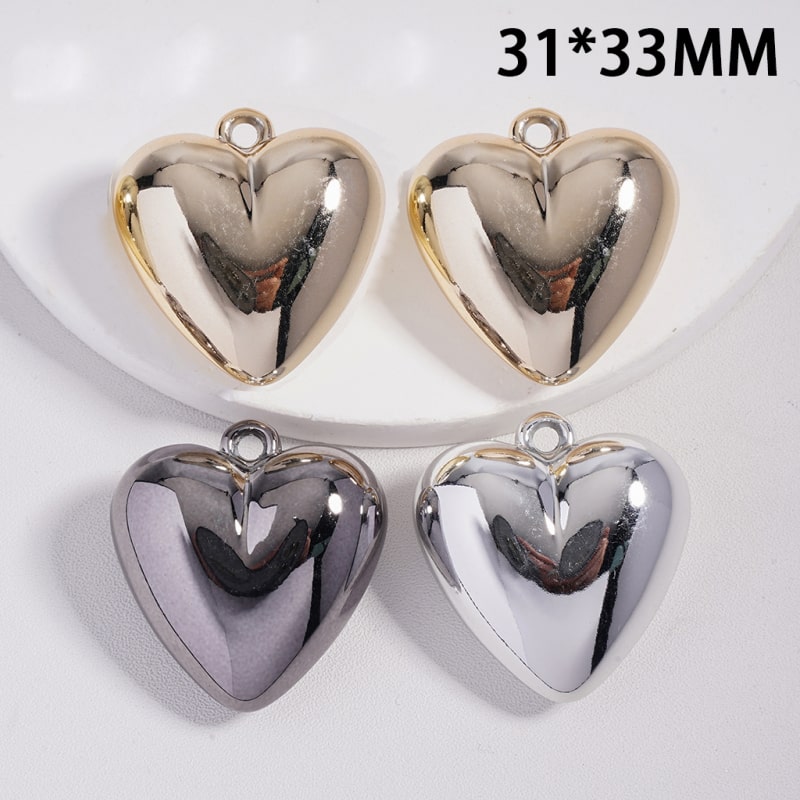 Four metallic heart-shaped pendants on a white background with dimensions 31*33MM.


