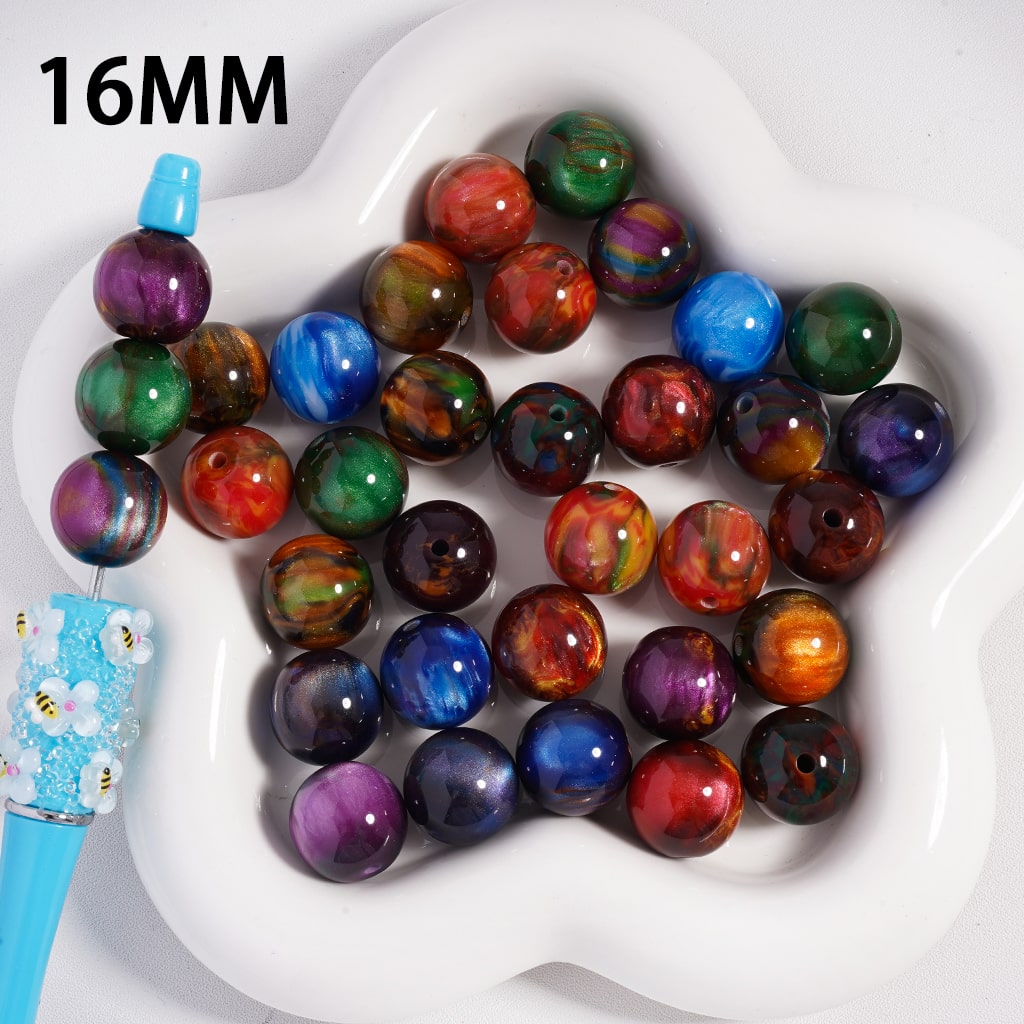 Multicolored beads on a white heart-shaped tray with a blue tool

