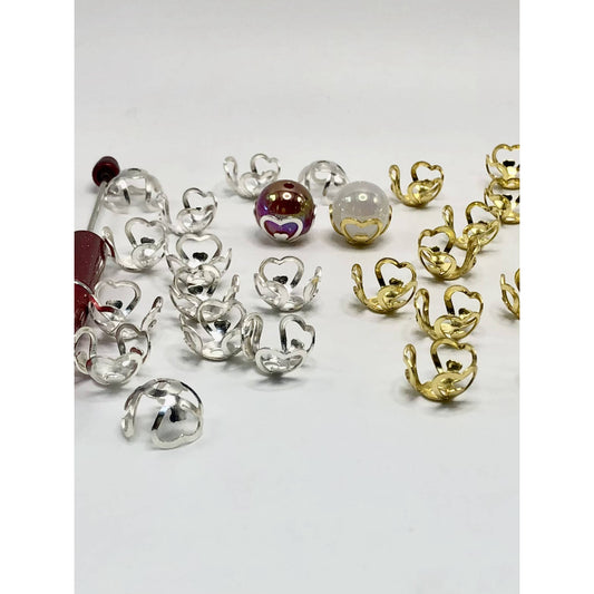 A collection of heart-shaped bead cage caps in clear and gold colors intended for use with 16mm beads, displayed on a white surface.

