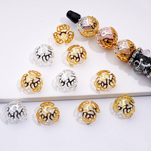 Gold, silver, and black decorative beads on a white surface

