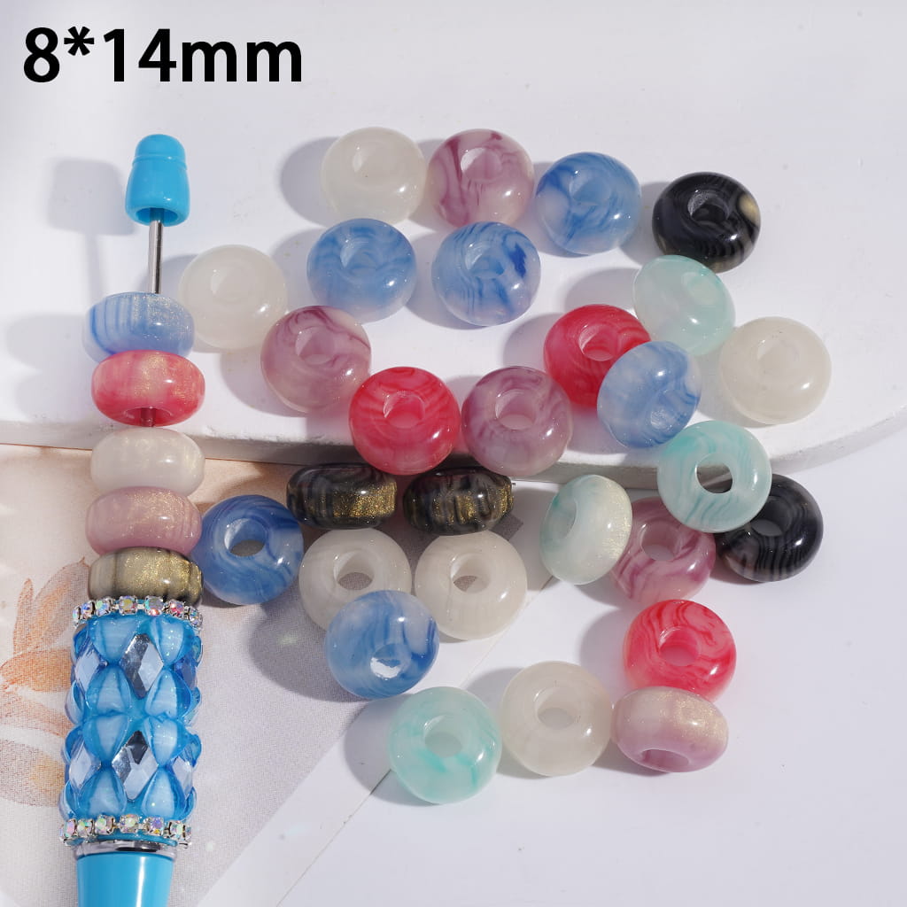 Assorted colorful beads with a blue and silver tool on a white background