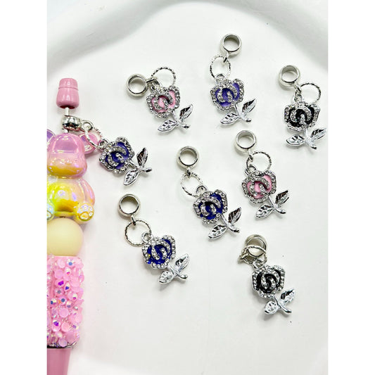 A collection of multicolored charm chains with rose alloy clear rhinestones intended for use with pens, displayed against a white background.

