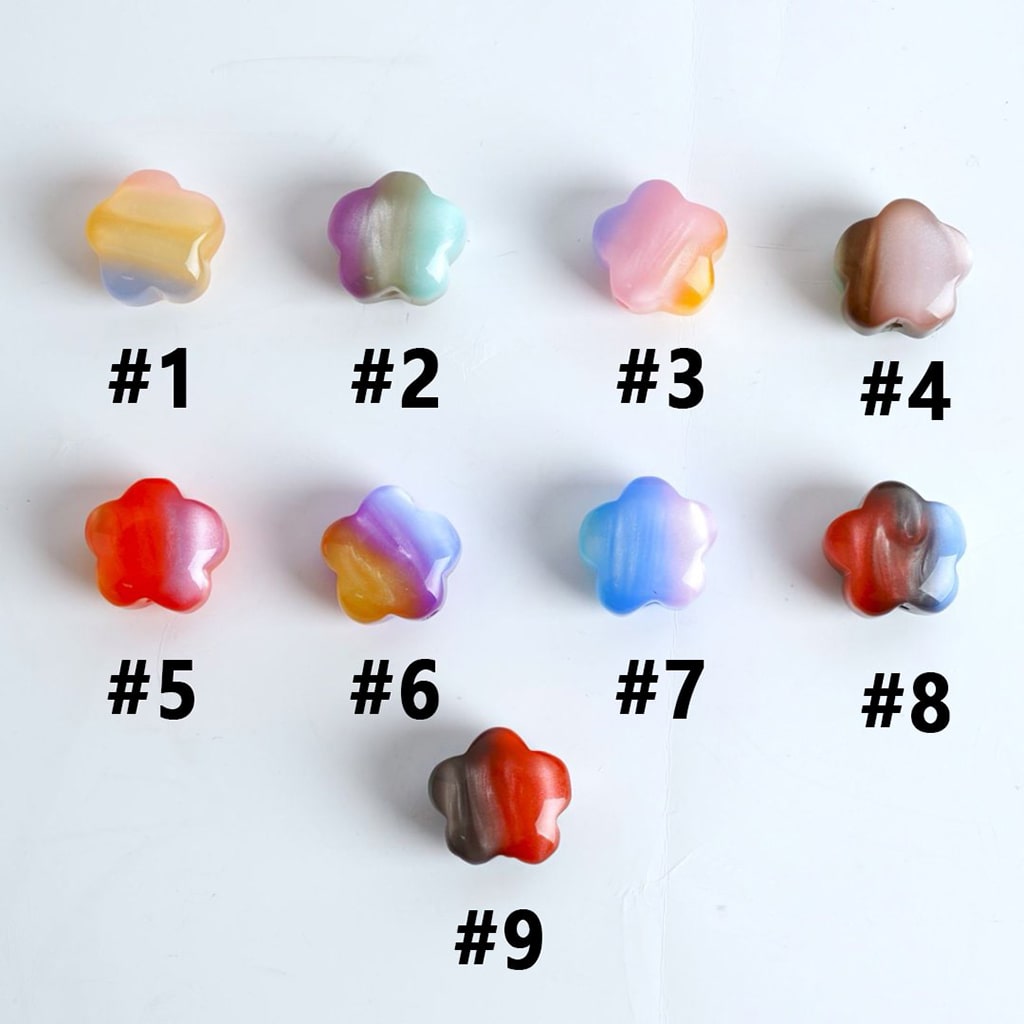 A collection of multicolored acrylic beads shaped like flowers, displayed on a white surface.

