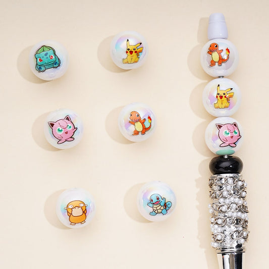A collection of white acrylic beads with pearl white finish featuring cartoon pocket monster designs, displayed on a beige background with a pen adorned with the beads.

