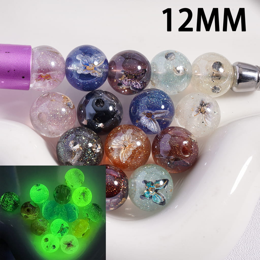 Colorful beads with embedded butterflies, some glowing green, on a white background.