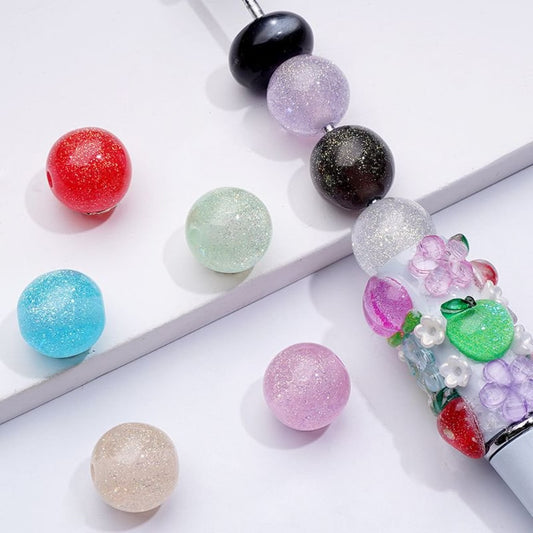 A collection of colorful round acrylic beads in glittery finish, displayed in various colors including red, blue, green, purple, beige, black, and clear.

