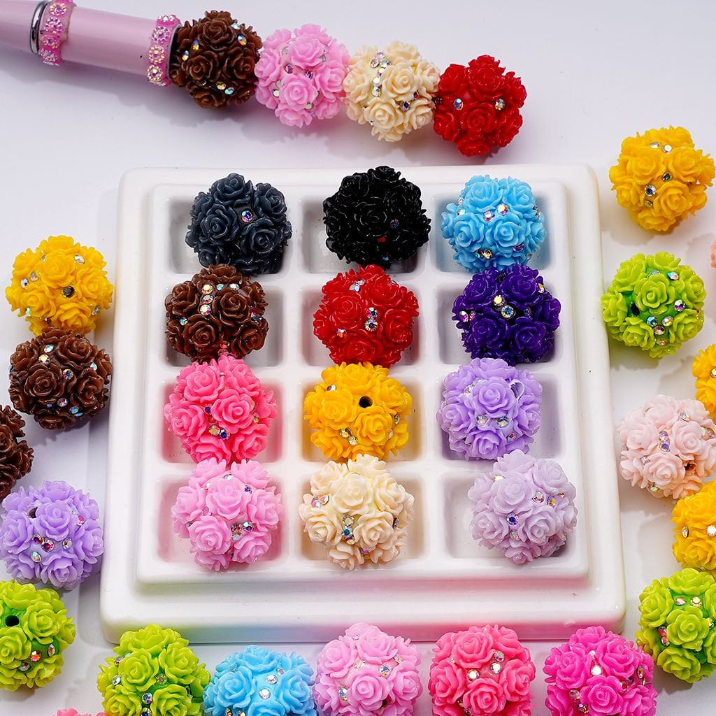 Assorted colorful flower-shaped earrings in a white tray with a pink border.

