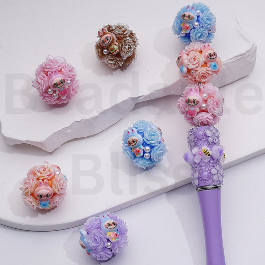 Decorative pen with floral designs and small figurines on a white background

