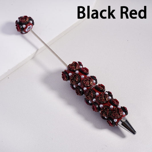 Decorative pen with red floral and pearl design on a white background

