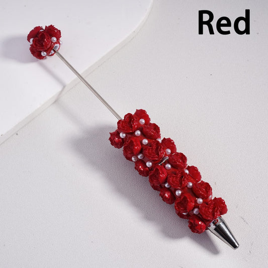 Red floral and pearl brooch on a white background

