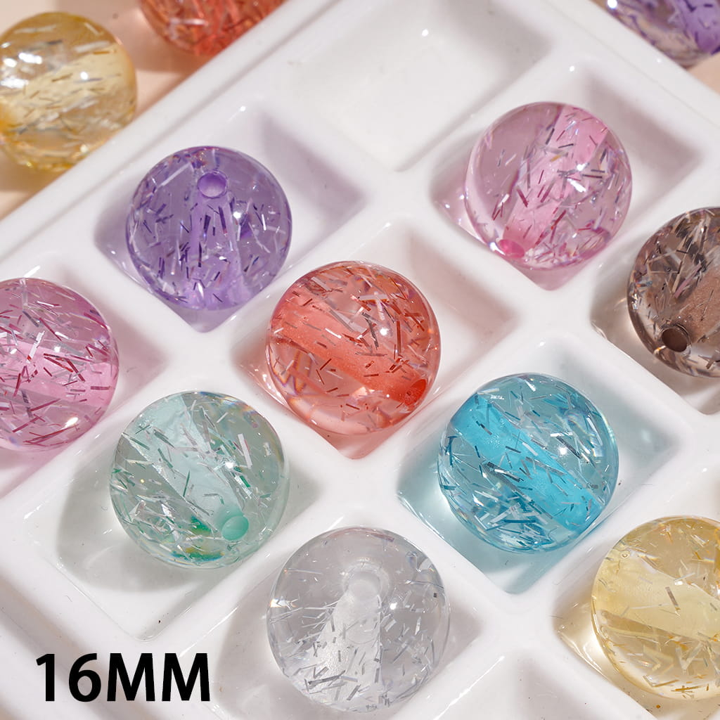 Assorted colored gemstones in a white tray with '16MM' text.

