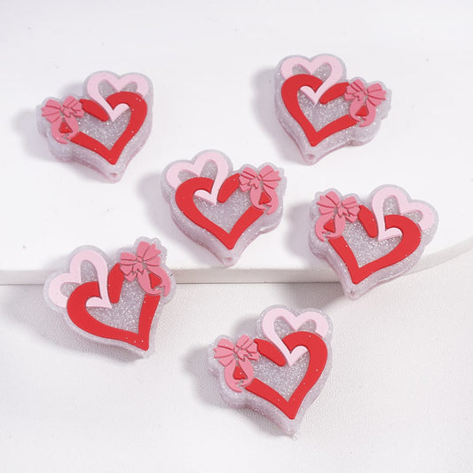 Heart-shaped decorative items with pink bows on a white background

