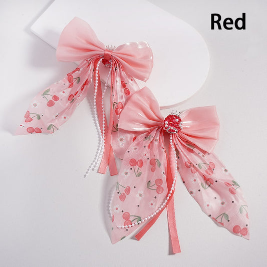 Pink decorative bow with cherry pattern on a white background

