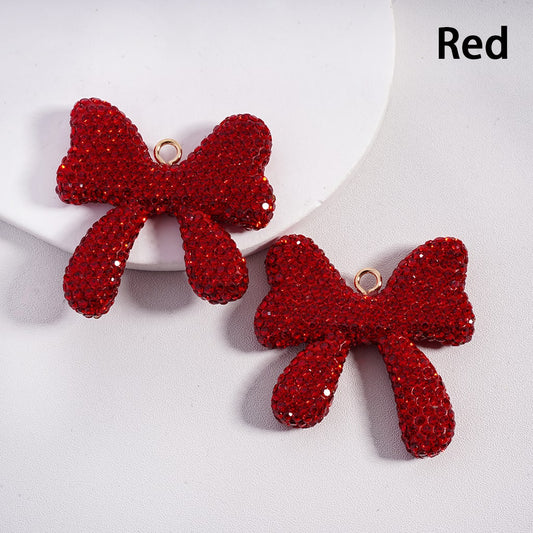 Red bow-shaped earrings on a white background

