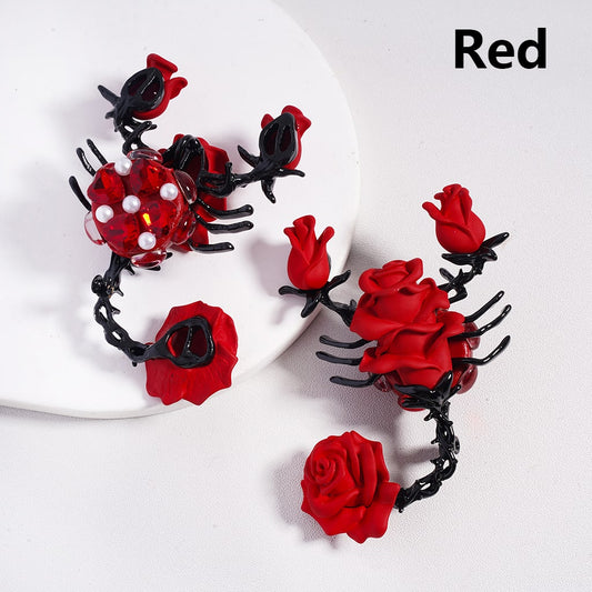 Red and black rose-shaped jewelry piece on a white plate

