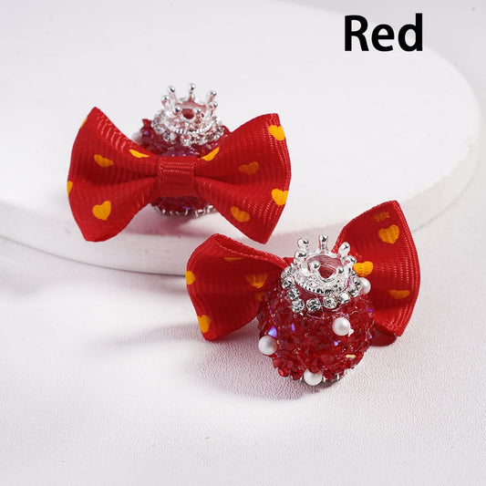 Red bow hair clips with decorative elements on a white background

