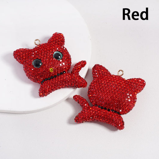 Red cat-shaped earrings on a white plate with 'Red' text above.

