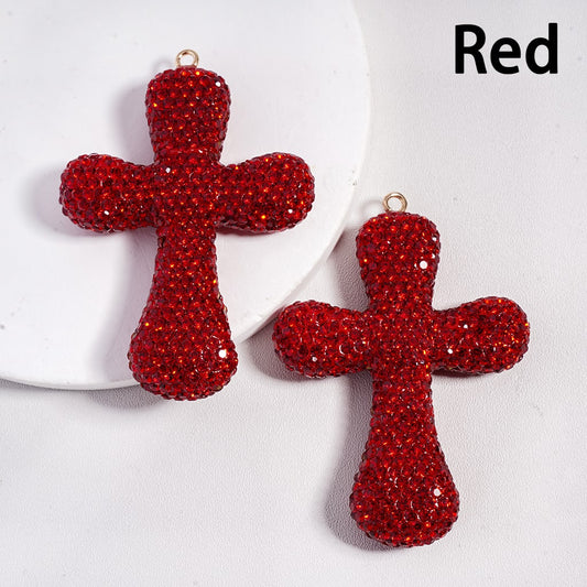 Red cross-shaped earrings on a white background
