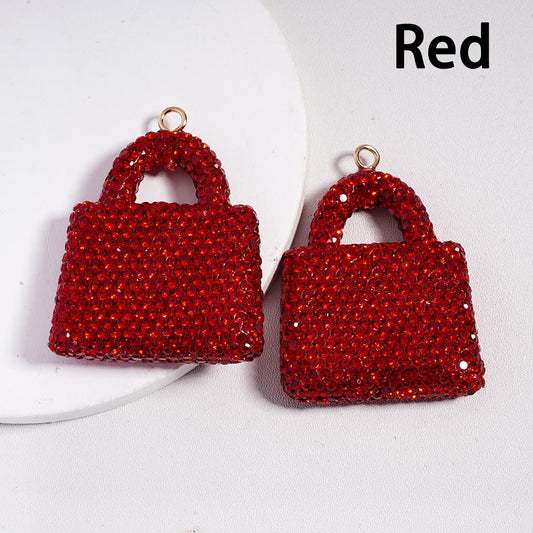 Red handbag-shaped earrings on a white background with 'Red' text.
