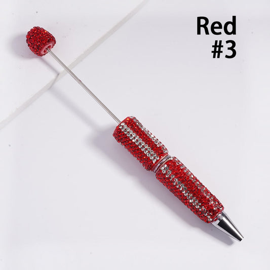 Red decorative pen with gemstones on a white background

