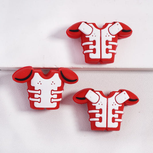 Three red and white shoulder pads on a light gray background

