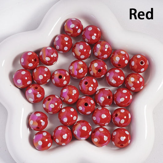 Red beads with white polka dots on a white plate