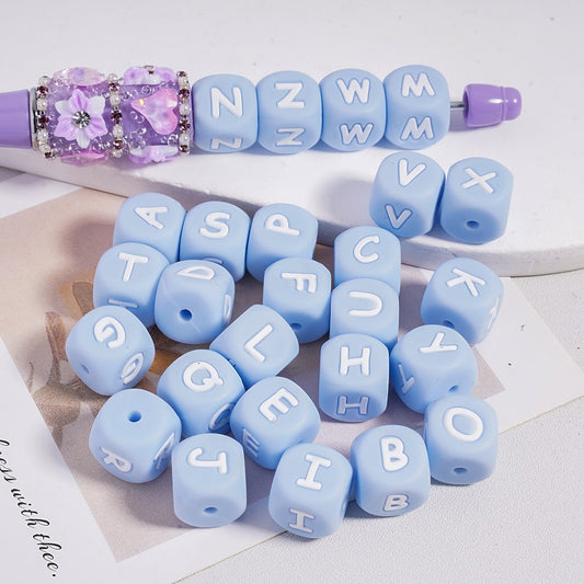 Blue letter beads with white letters on a white surface