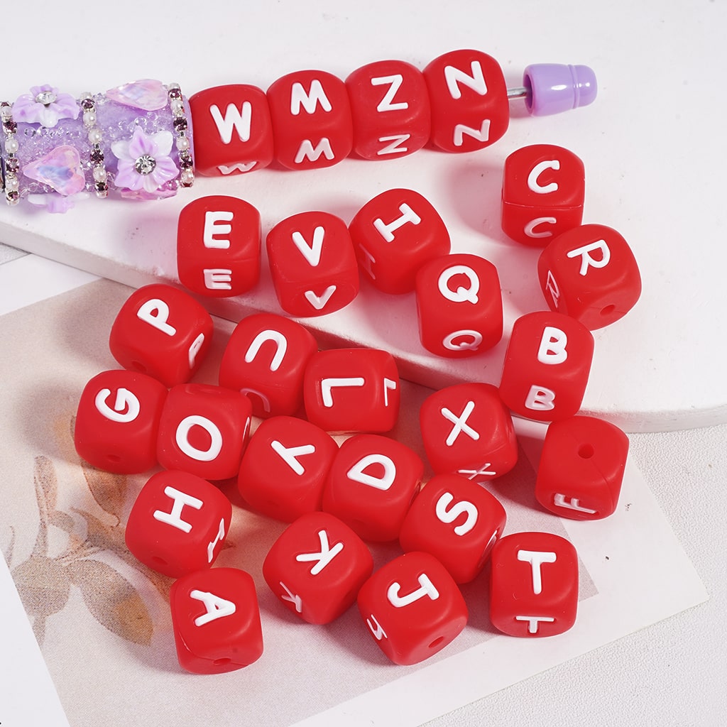 Red letter beads with white letters on a white surface