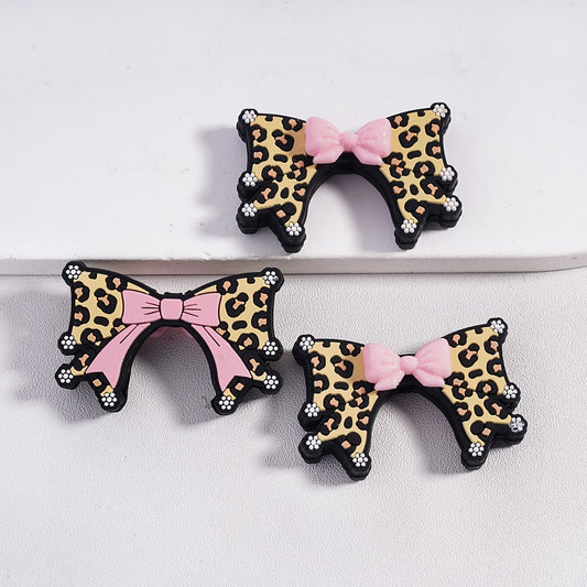 Leopard print hair bows with pink centers on a white background