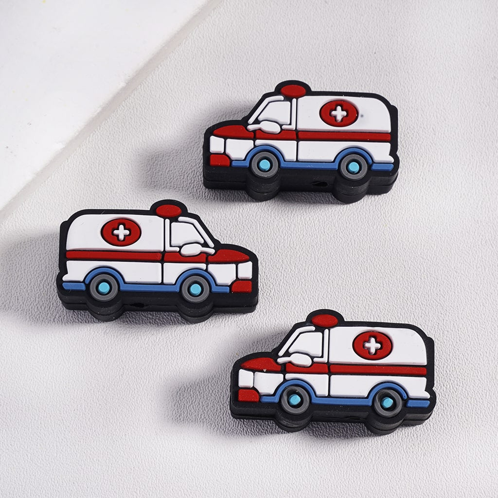 Three cartoon-style ambulance pins on a light gray background