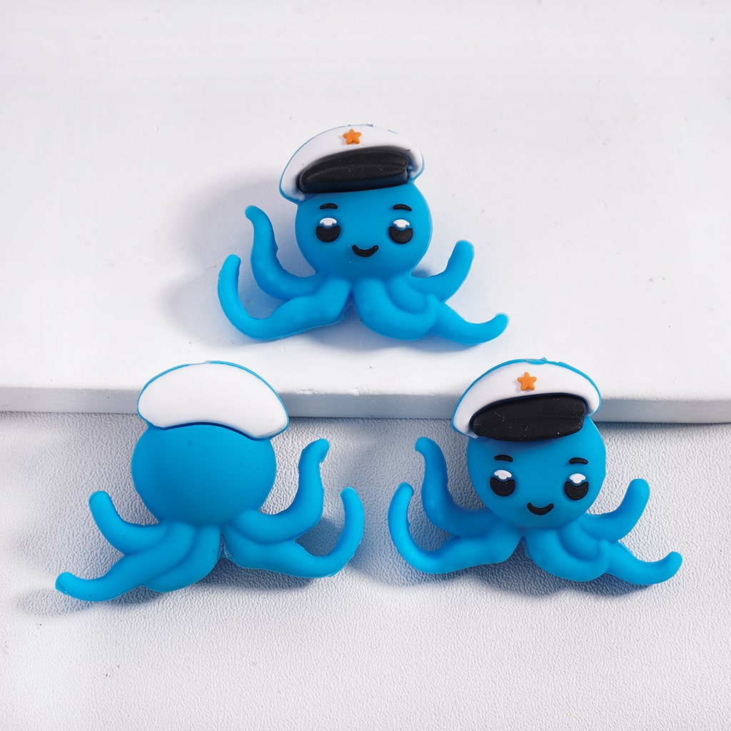 Three blue octopus figurines with sailor hats on a white background