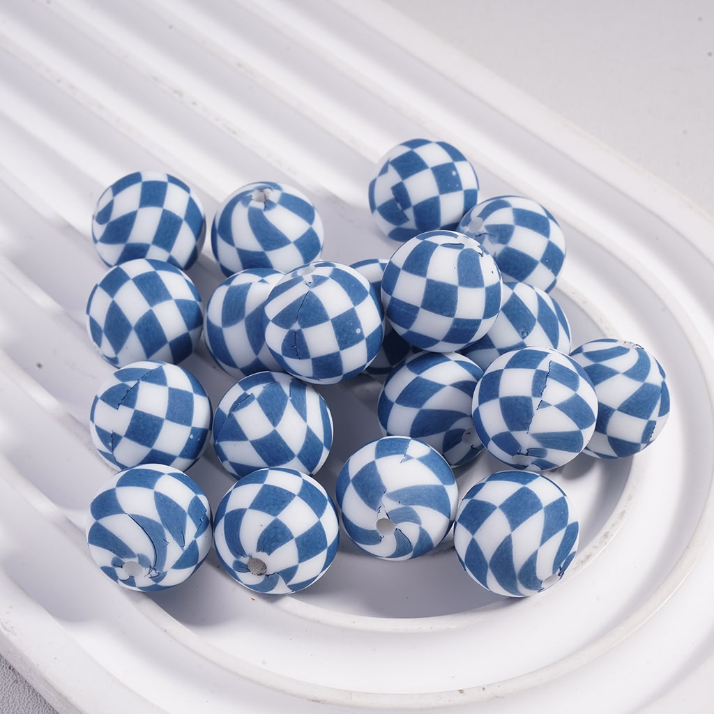 Blue and white checkered beads on a white textured surface