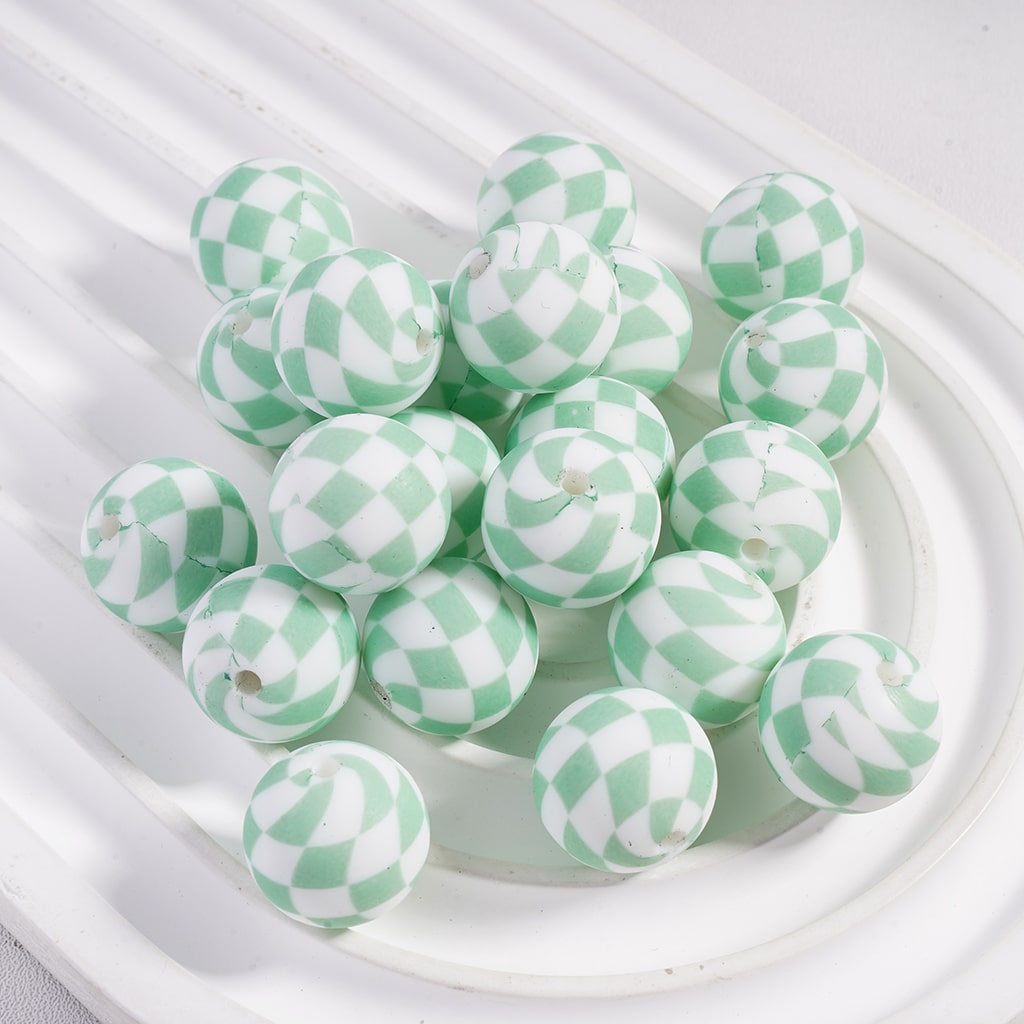 Green and white checkered beads on a white plate