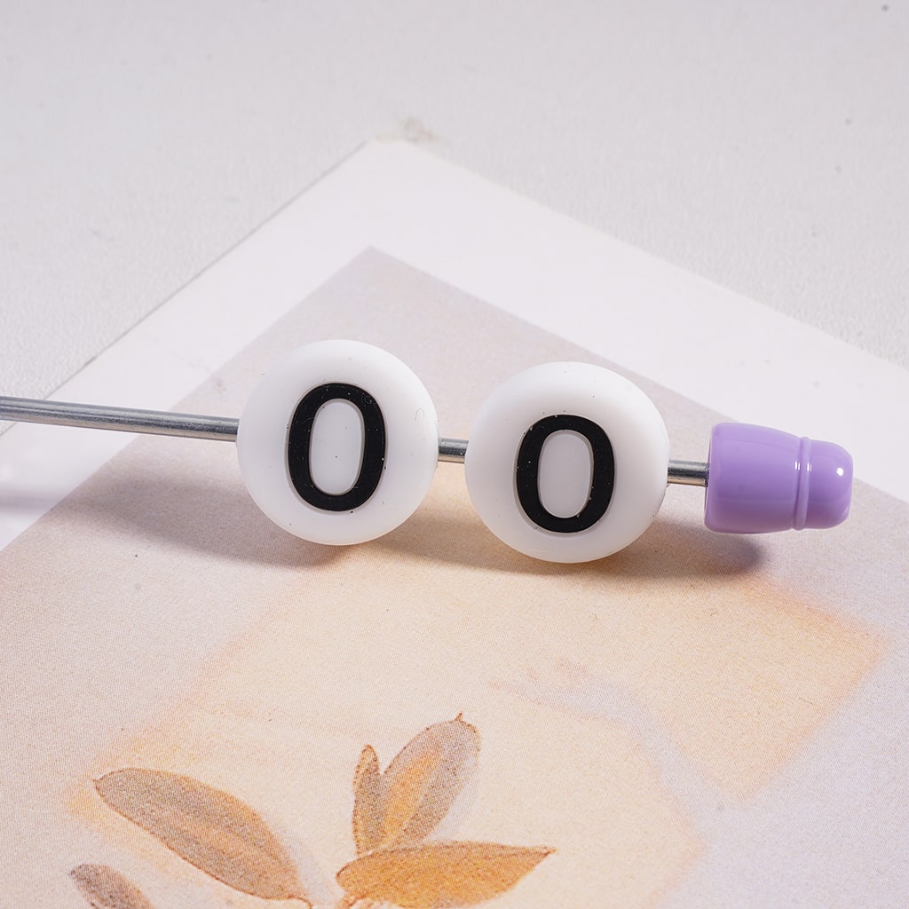 Beaded bar with '00' on white beads and purple end cap on a textured surface.