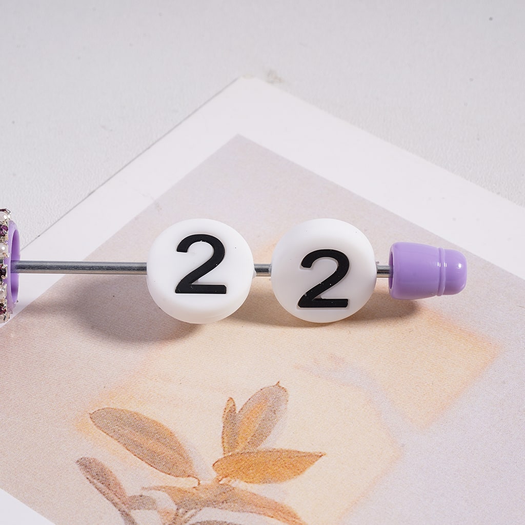 Belly button ring with white beads displaying the number 22 on a light background.