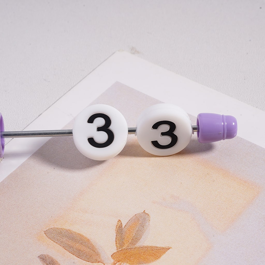 Two white baby bottles with number 3 labels on a textured surface.