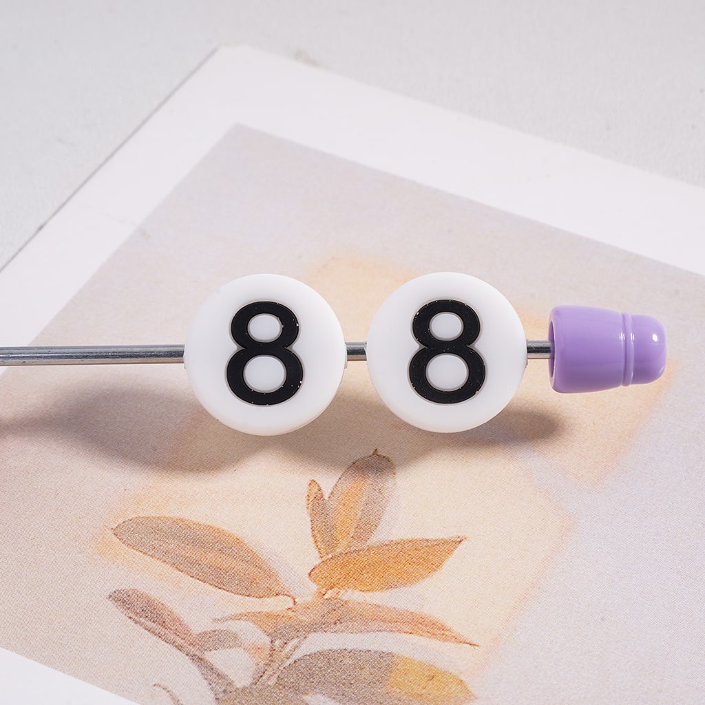 Two white beads with black number '8' on a silver bar with a purple end, on a light background.