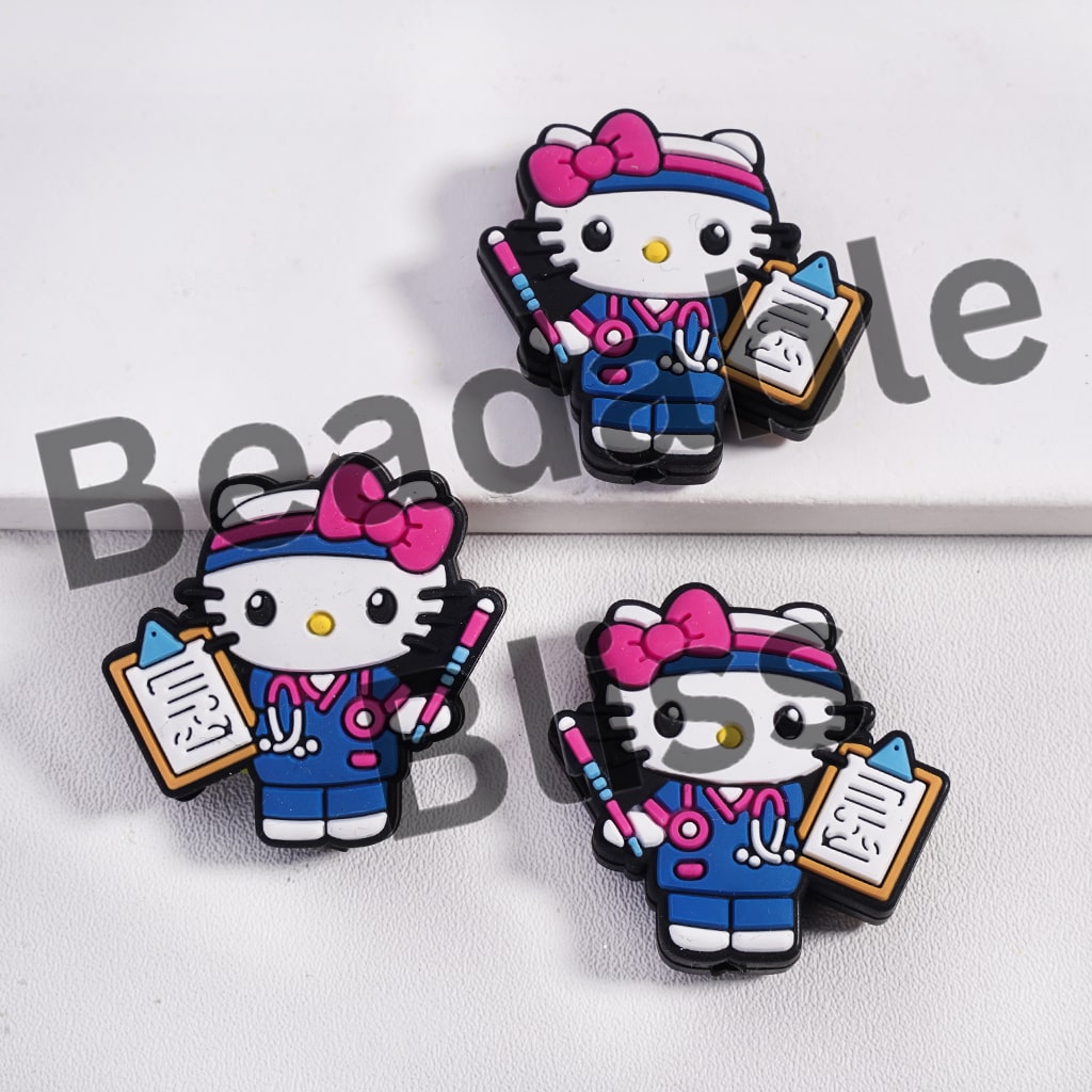 Three cartoon character pins with blue outfits and pink bows on a white background.

