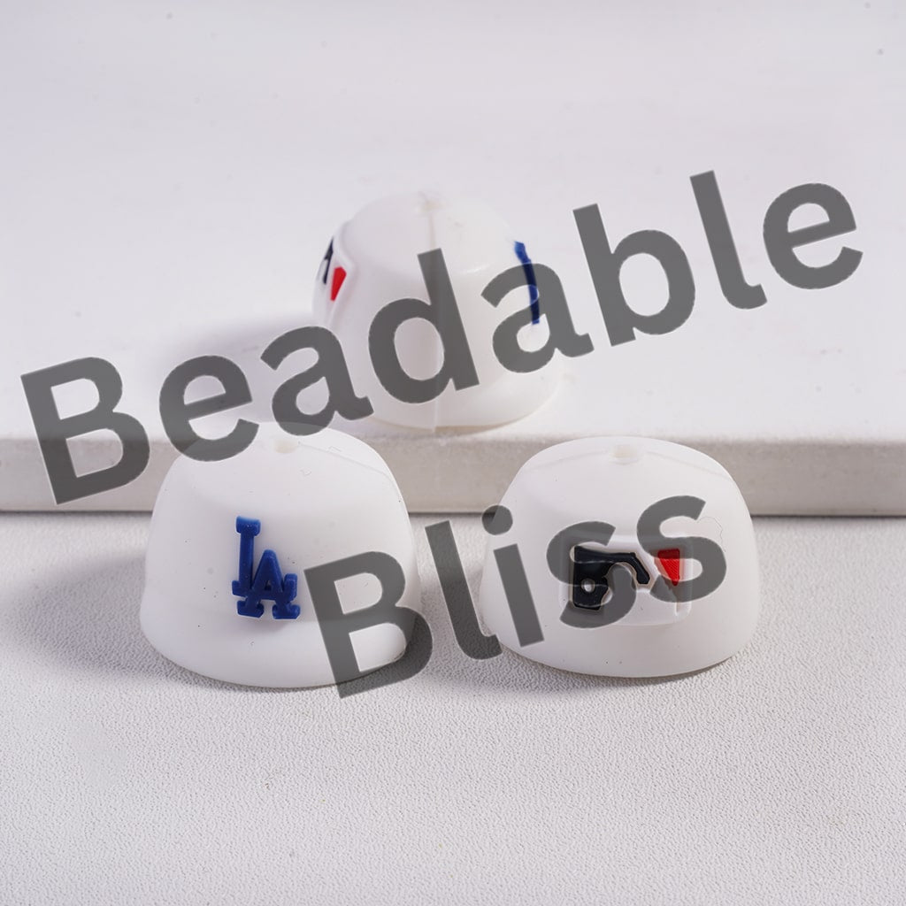 White earrings with blue and red accents on a light gray background, featuring 'Beadable Bliss' branding.