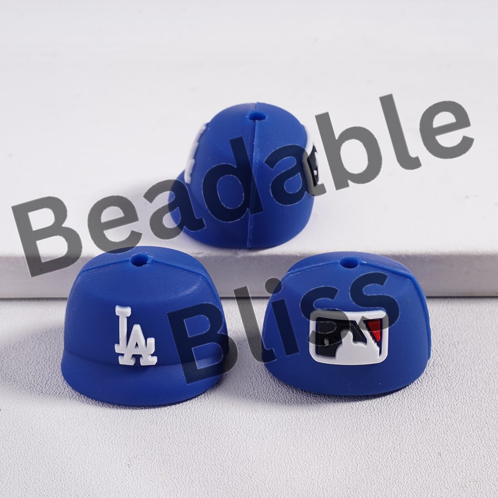 Three blue silicone beads with logos on a white background, branded 'Beadable Bliss'.