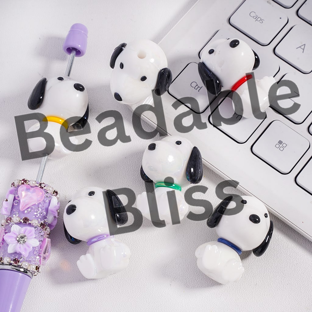 Dog-shaped earbud holders on a keyboard with 'beadablebliss' branding.