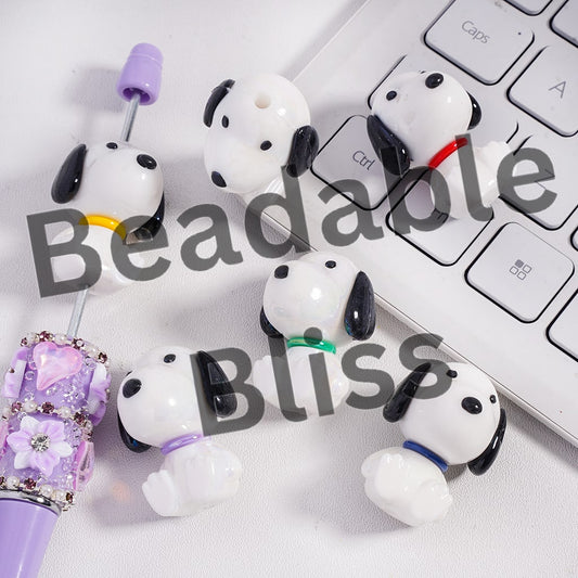 Dog-shaped earbud holders on a keyboard with 'beadablebliss' branding.