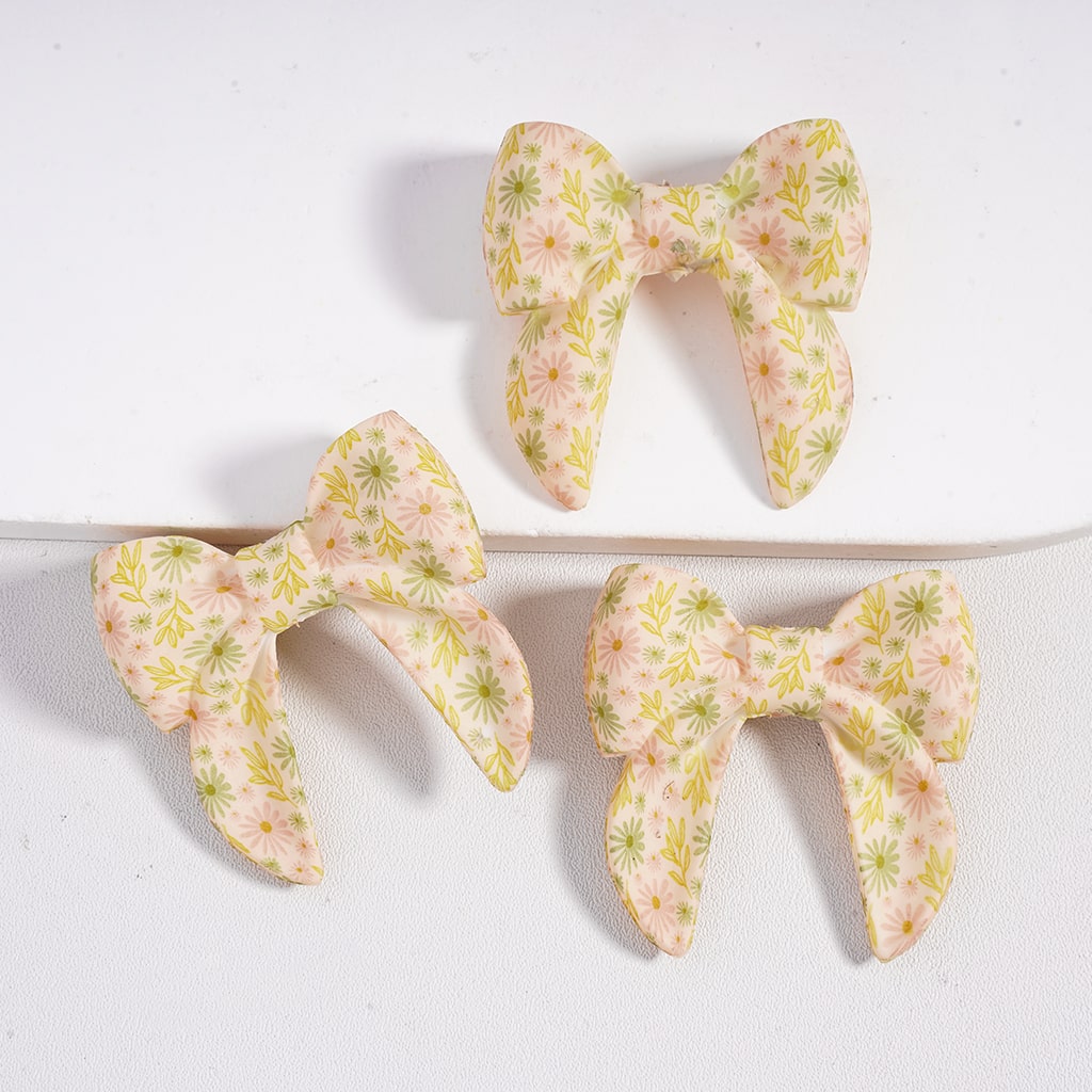 Three floral-patterned hair bows on a white background
