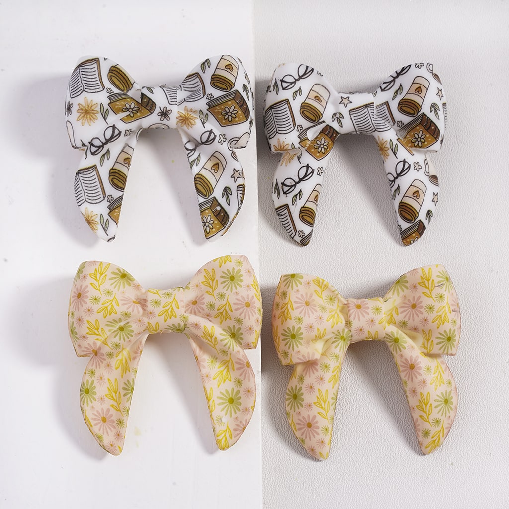 Four fabric bows with different patterns on a white background