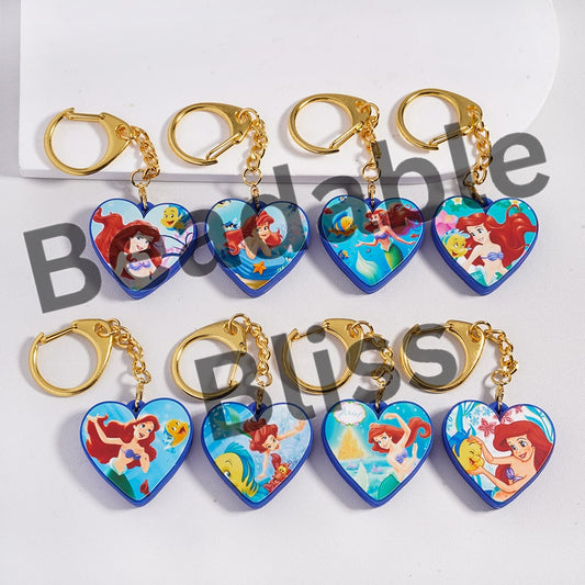 Heart-shaped keychains with cartoon characters on a white background