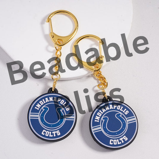 Two Indianapolis Colts keychains with gold hooks on a white background.