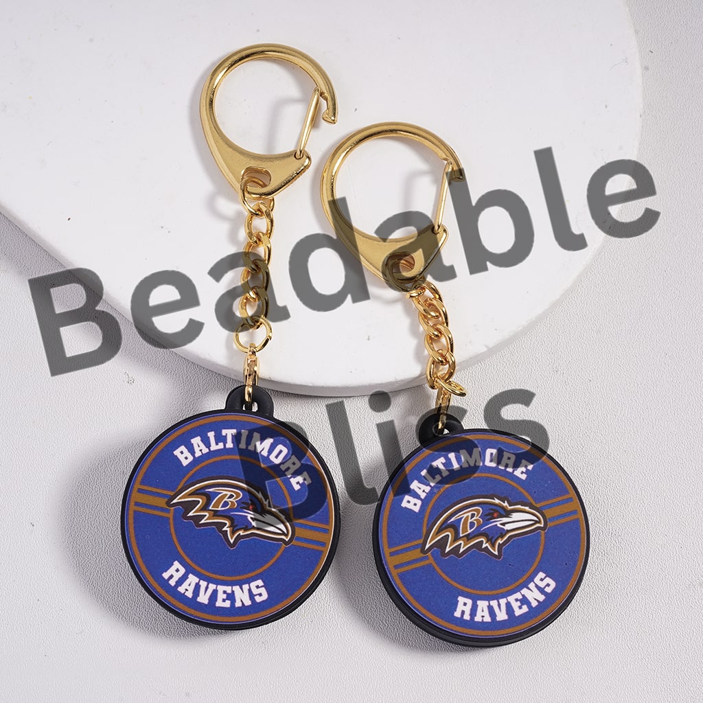 Two Baltimore Ravens keychains on a white background with 'beadablebliss' text.