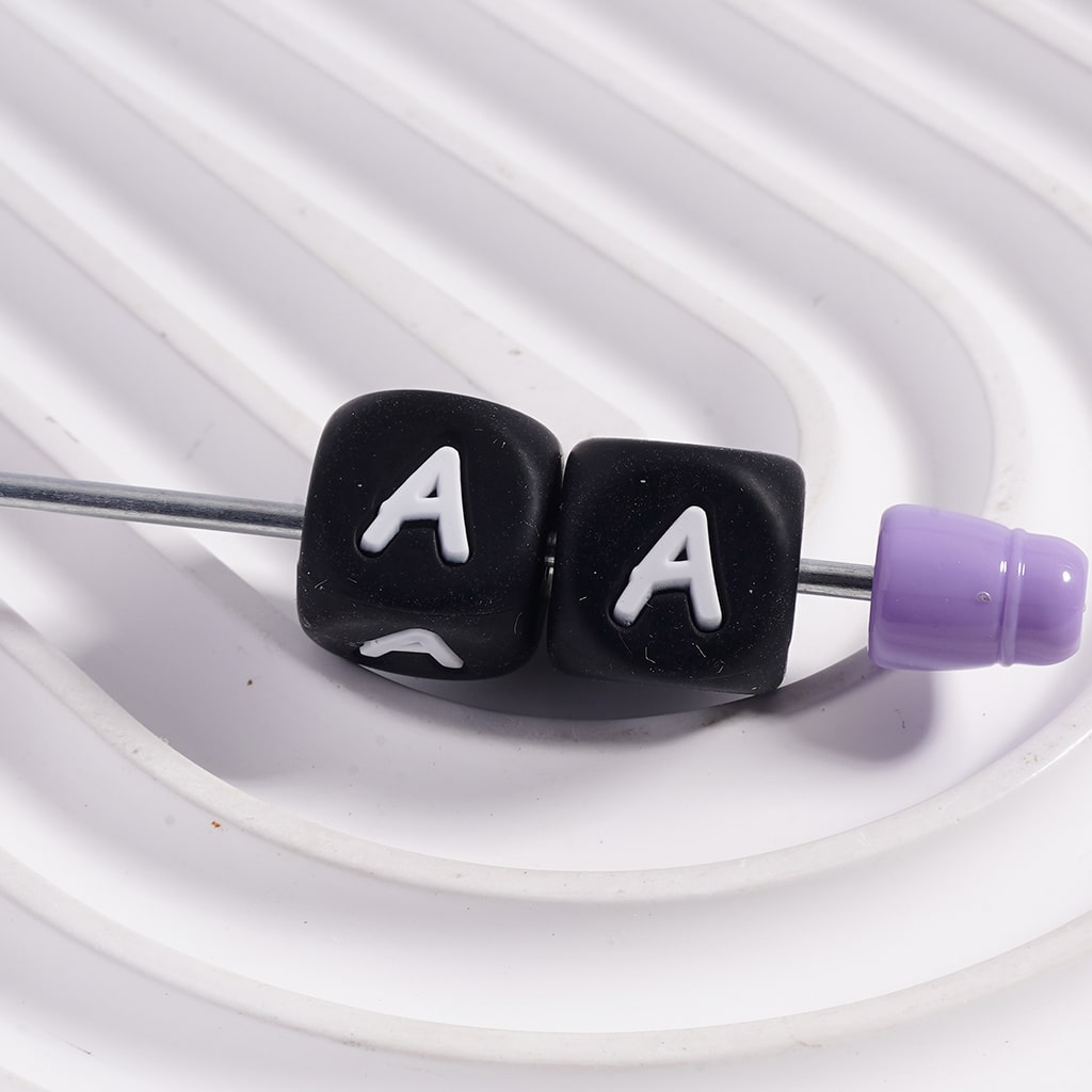 Black earbud with 'AA' letters and purple end on a white background