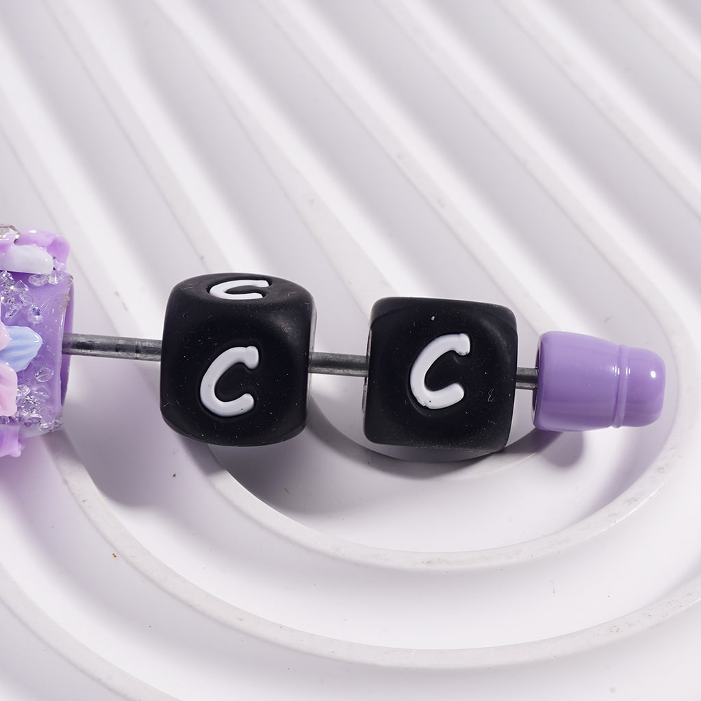 Beaded charm with letter 'C' on a white background