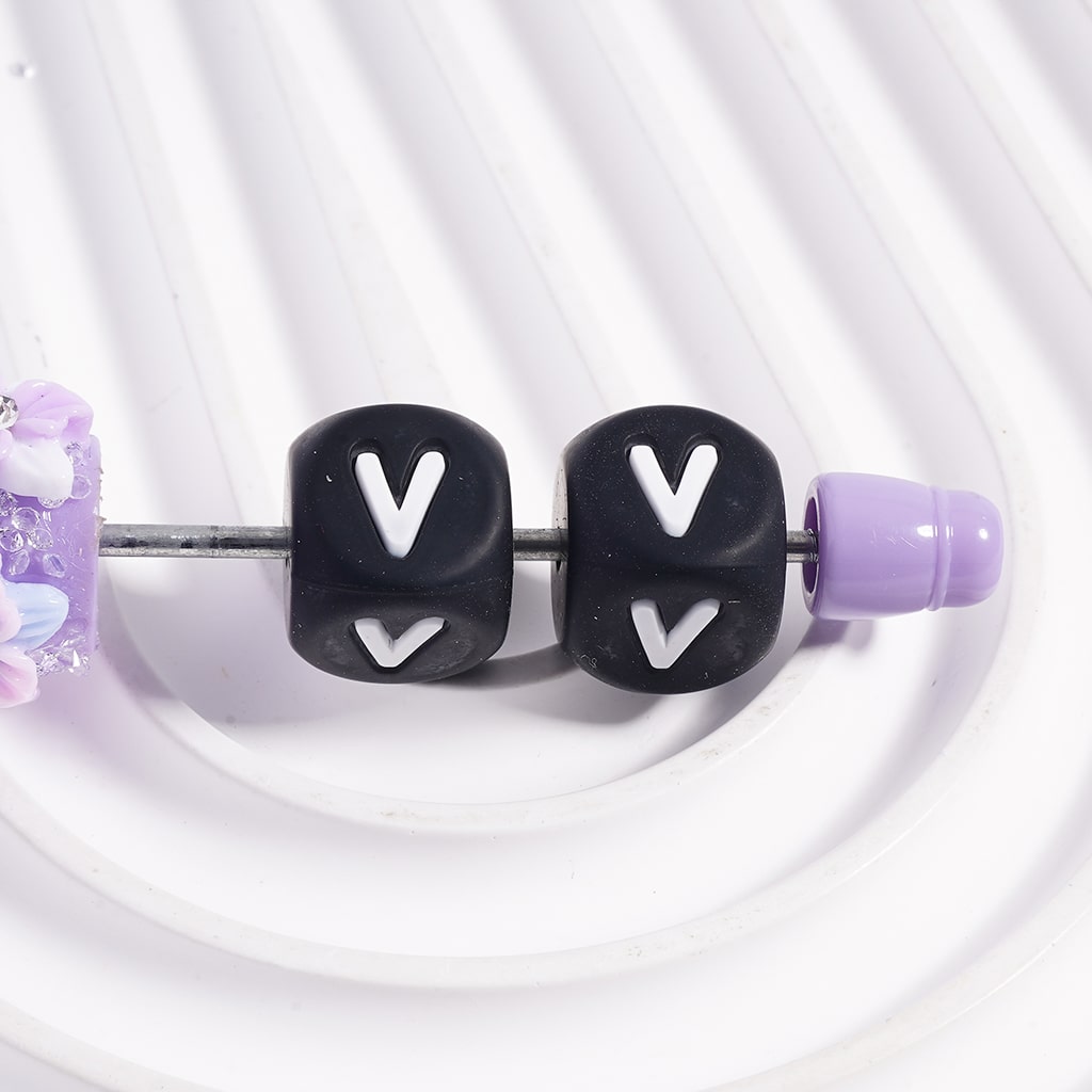 Black beads with 'V' lettering on a white background